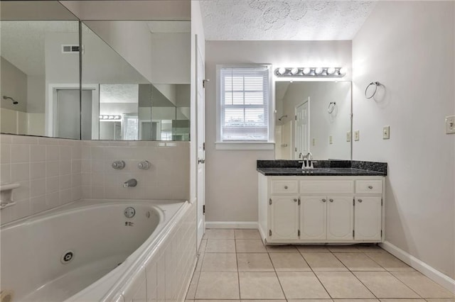 bathroom featuring vanity, tile patterned flooring, a relaxing tiled tub, and a textured ceiling