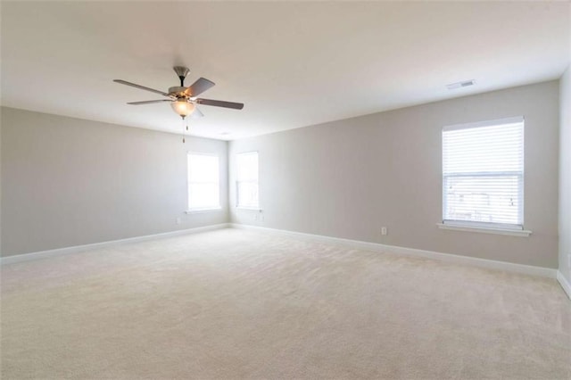 spare room with ceiling fan and light colored carpet