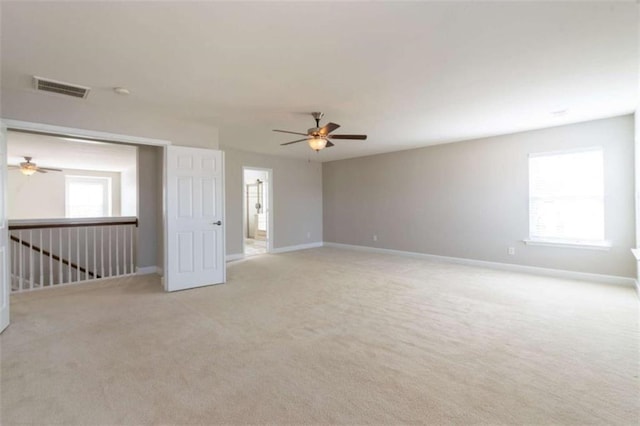 spare room featuring light colored carpet and ceiling fan