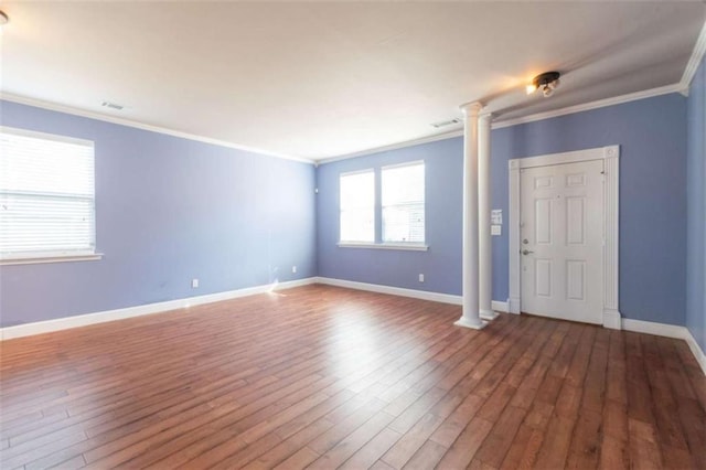 interior space featuring crown molding, wood-type flooring, and ornate columns