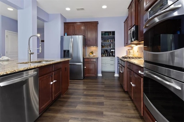 211 Parc Dr, Canton, GA 30114 - kitchen featuring appliances with stainless steel finishes, a sink, light stone countertops, dark wood-style flooring, and backsplash