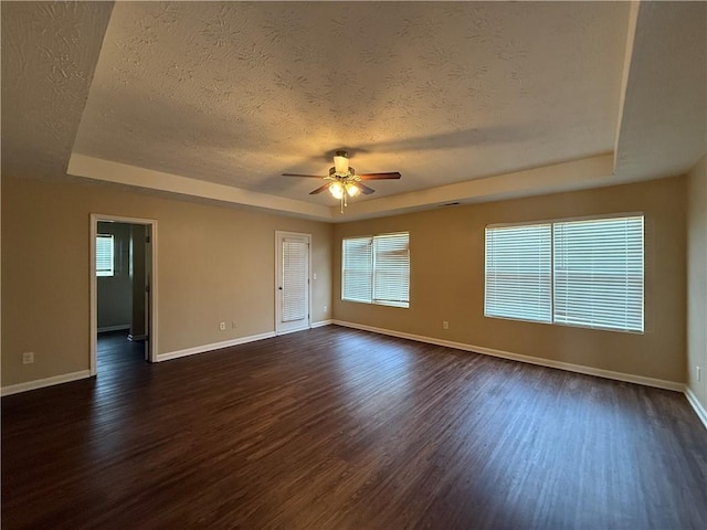 425 Bell Flower Trl, Locust Grove, GA 30248 - unfurnished room with a raised ceiling, a textured ceiling, dark wood finished floors, and a ceiling fan
