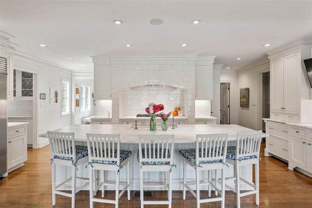 675 W Paces Ferry Rd NW Unit 11, Atlanta, GA 30327 - kitchen with white cabinetry, a kitchen breakfast bar, tasteful backsplash, and crown molding