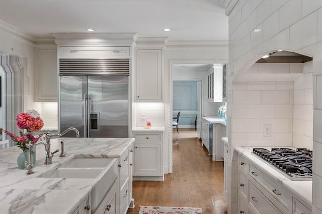 675 W Paces Ferry Rd NW Unit 11, Atlanta, GA 30327 - kitchen featuring light wood-style flooring, ornamental molding, a sink, white cabinetry, and stainless steel appliances