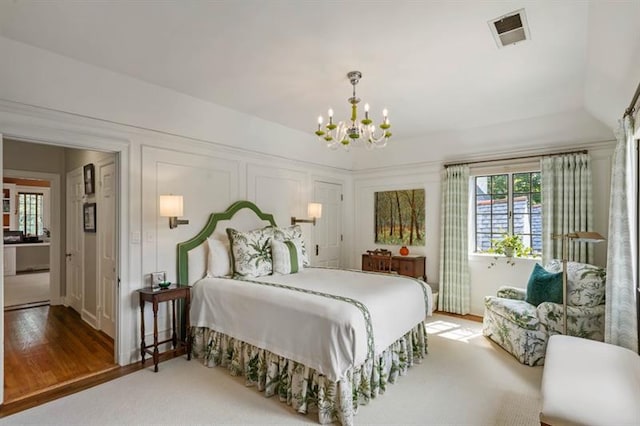 675 W Paces Ferry Rd NW Unit 11, Atlanta, GA 30327 - bedroom with a notable chandelier, visible vents, and wood finished floors