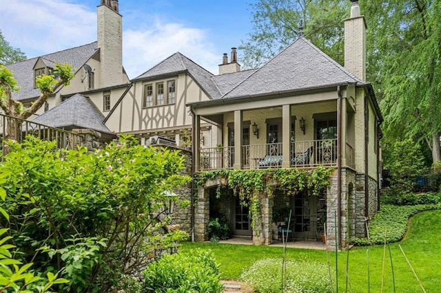 675 W Paces Ferry Rd NW Unit 11, Atlanta, GA 30327 - back of property featuring a chimney, a balcony, stone siding, and a lawn