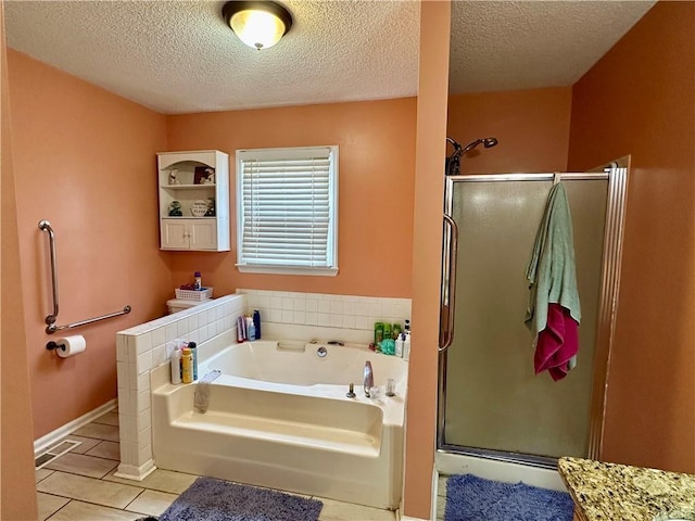 bathroom with a textured ceiling, a stall shower, tile patterned flooring, and a bath