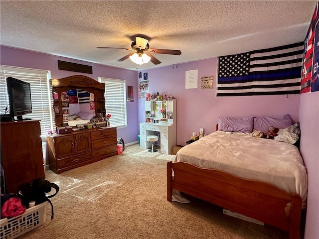 bedroom featuring a ceiling fan, light colored carpet, a textured ceiling, and baseboards