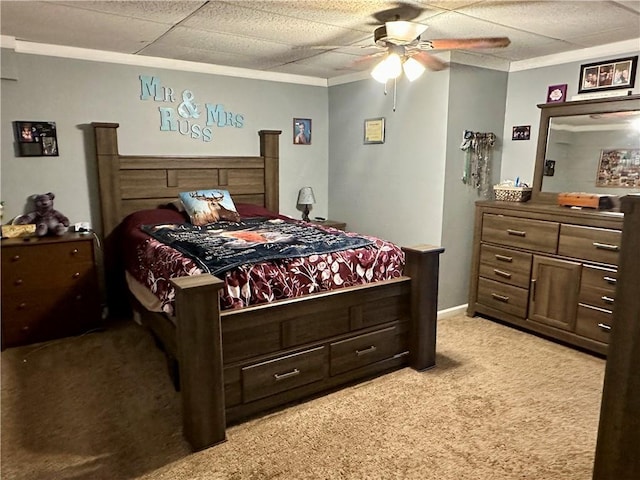 bedroom featuring crown molding, light colored carpet, a ceiling fan, a drop ceiling, and baseboards