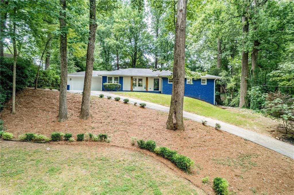 ranch-style home featuring a garage and a front lawn