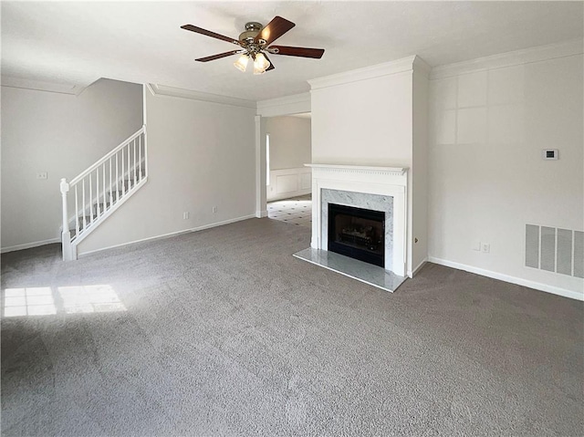 unfurnished living room featuring visible vents, stairway, a fireplace, and ornamental molding