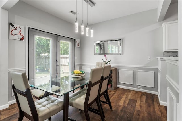 dining space with wainscoting, dark wood-style flooring, and visible vents