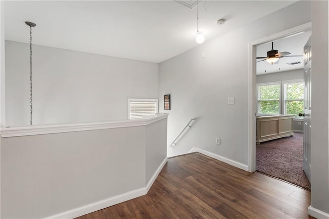spare room featuring baseboards, attic access, a ceiling fan, and wood finished floors