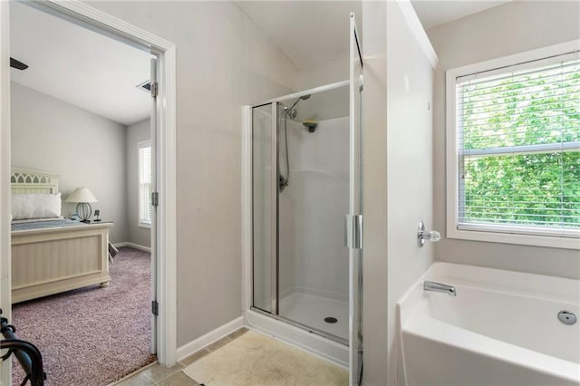 full bath with a garden tub, tile patterned floors, baseboards, and a stall shower
