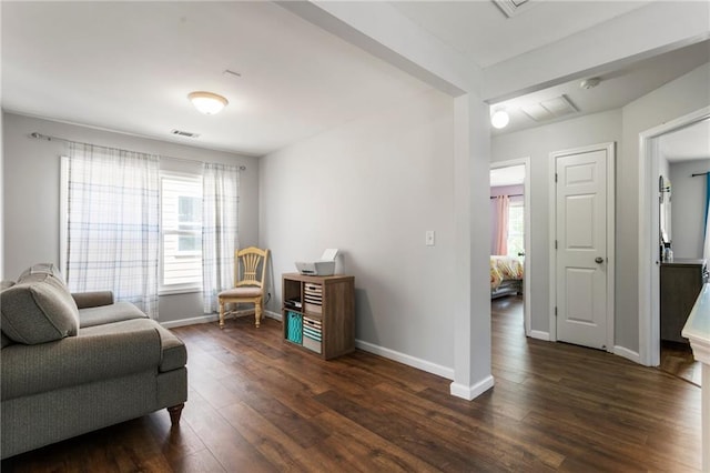 living area featuring dark wood-style flooring, baseboards, and visible vents