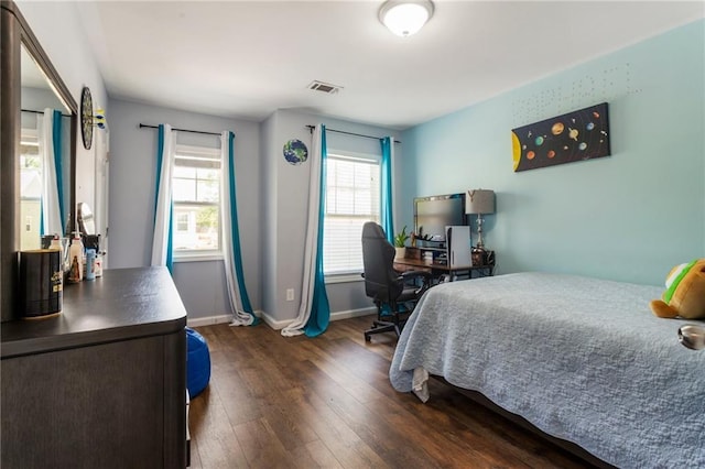 bedroom with dark wood-type flooring, baseboards, and visible vents