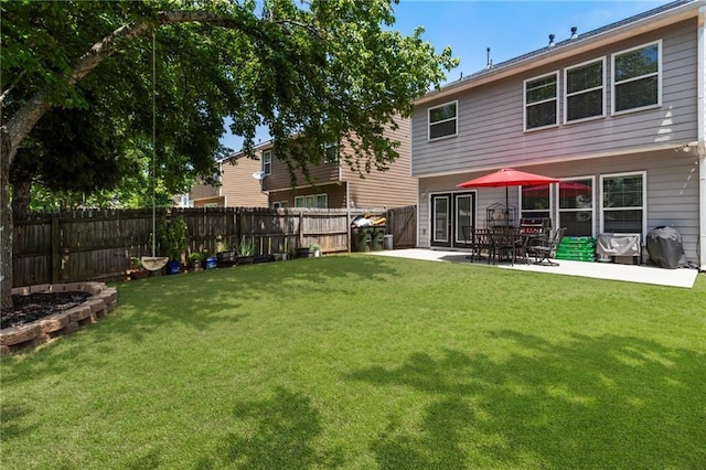 rear view of property with a lawn, a fenced backyard, and a patio area