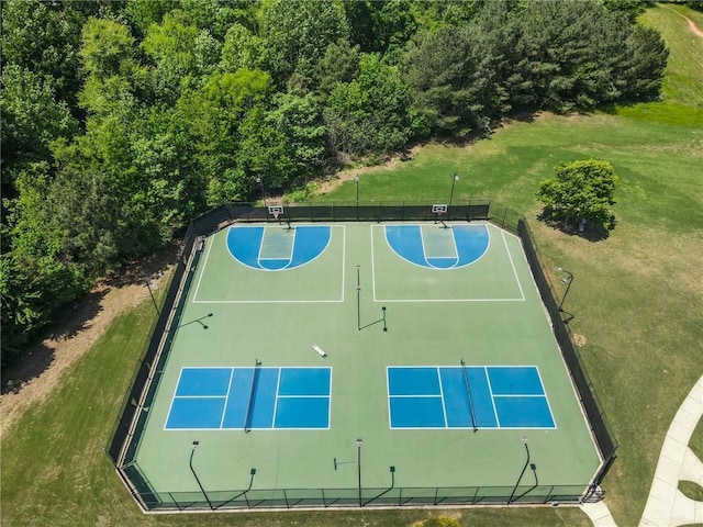 view of sport court with fence, community basketball court, and a yard