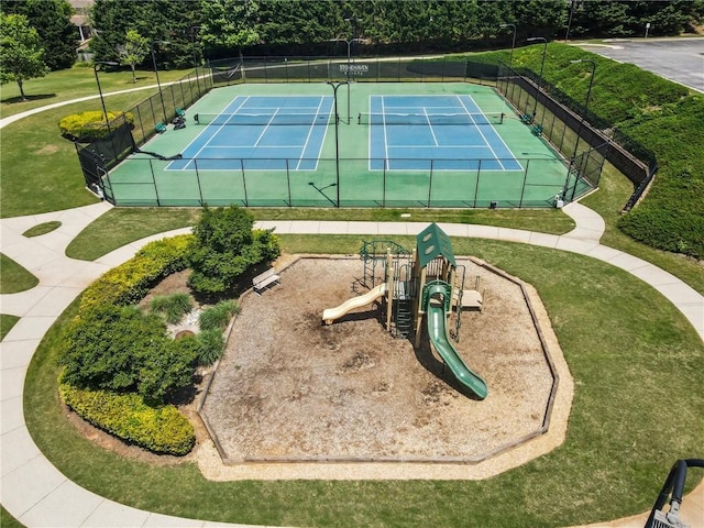 view of sport court with fence, a yard, and playground community