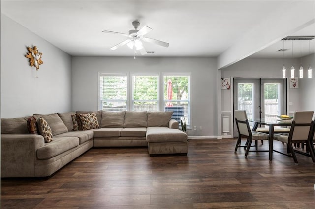 living room with dark wood-type flooring, baseboards, ceiling fan, and a wealth of natural light