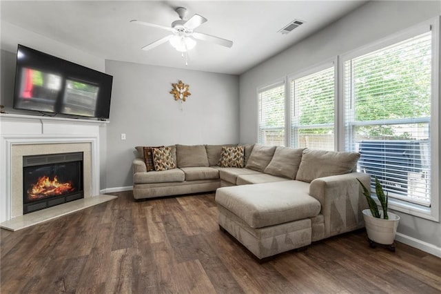 living room with visible vents, a fireplace, baseboards, ceiling fan, and dark wood-style floors