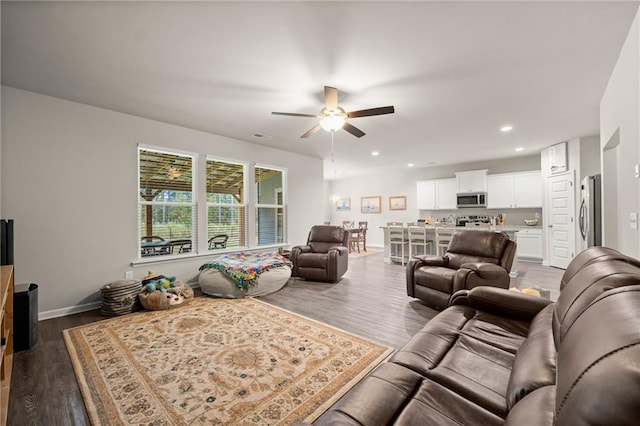 living room featuring ceiling fan and dark hardwood / wood-style floors