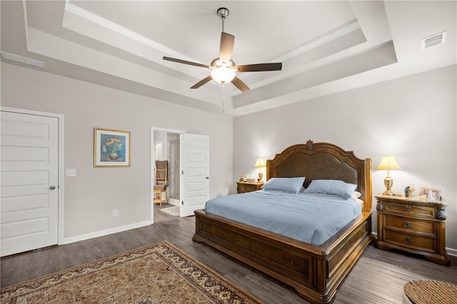 bedroom featuring ceiling fan, dark wood-type flooring, and a raised ceiling