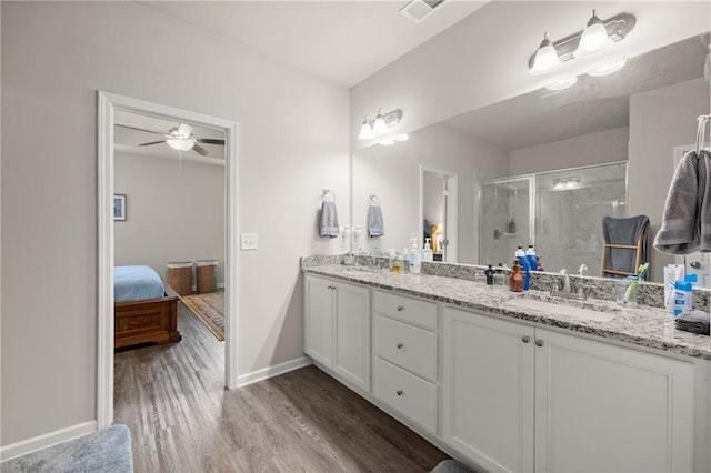 bathroom featuring a shower with door, hardwood / wood-style flooring, vanity, and ceiling fan