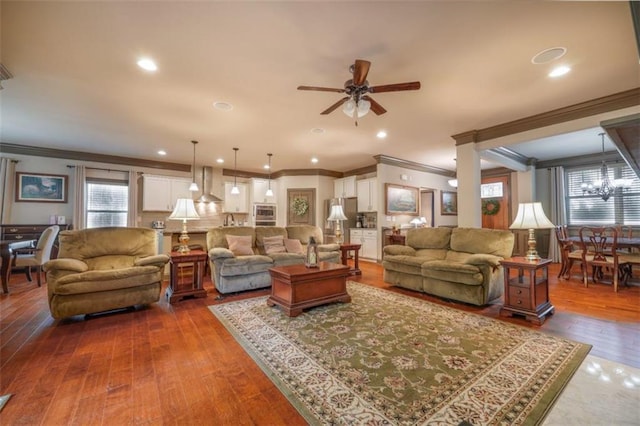 living room featuring crown molding, dark hardwood / wood-style floors, and ceiling fan with notable chandelier