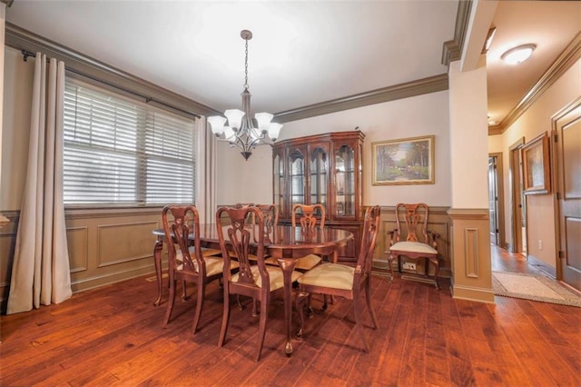 dining room with ornamental molding, dark wood-type flooring, and an inviting chandelier