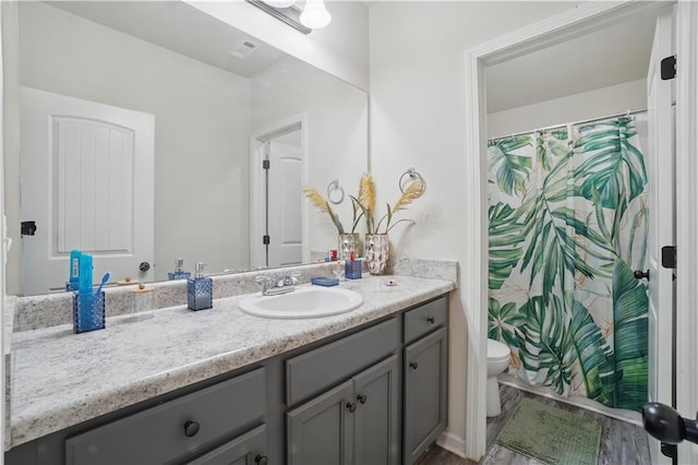 bathroom with vanity, a shower with shower curtain, and toilet