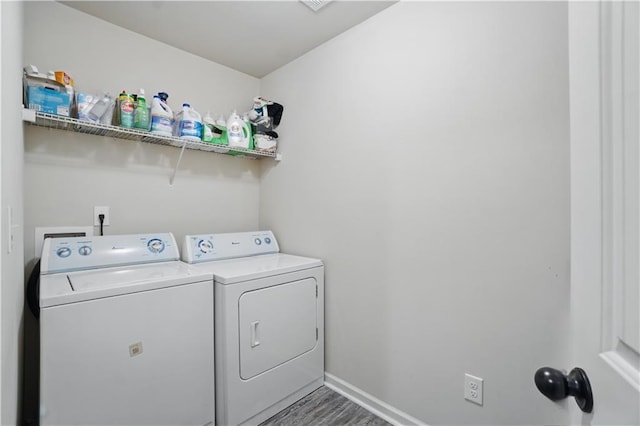 laundry area featuring baseboards, separate washer and dryer, laundry area, and wood finished floors