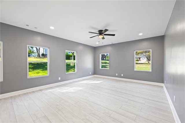 unfurnished room featuring light hardwood / wood-style floors, a healthy amount of sunlight, and ceiling fan