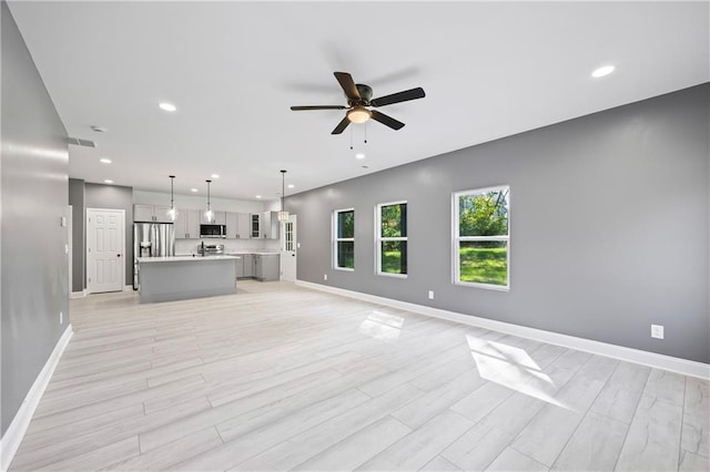 unfurnished living room with light hardwood / wood-style floors and ceiling fan