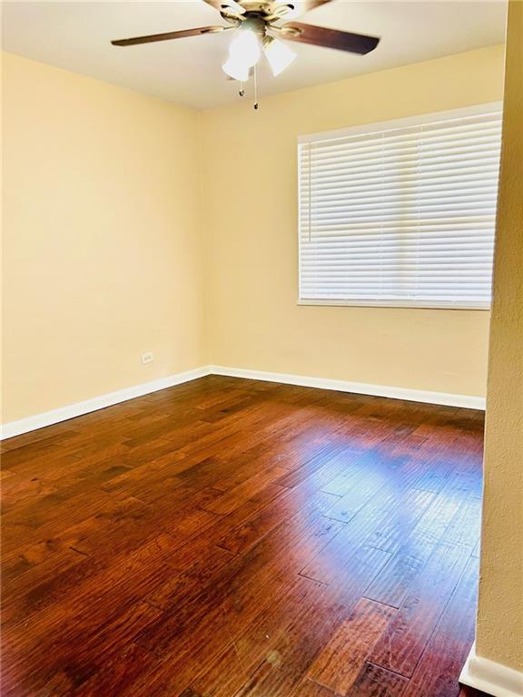 unfurnished room featuring ceiling fan and wood-type flooring