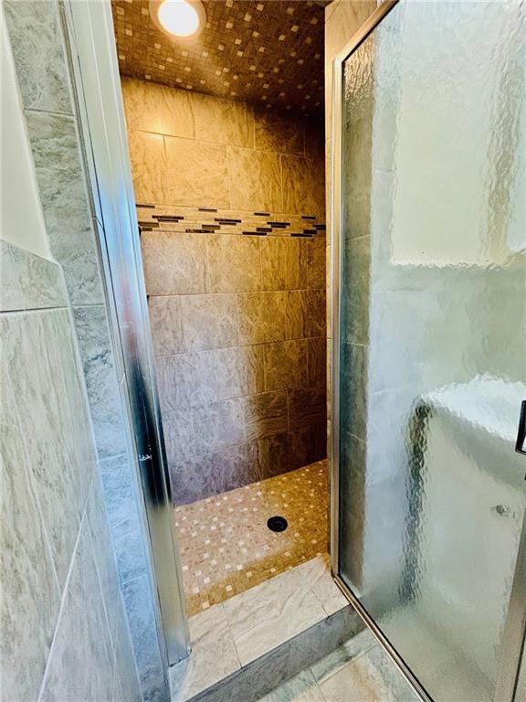 full bathroom with tile patterned flooring and a shower stall