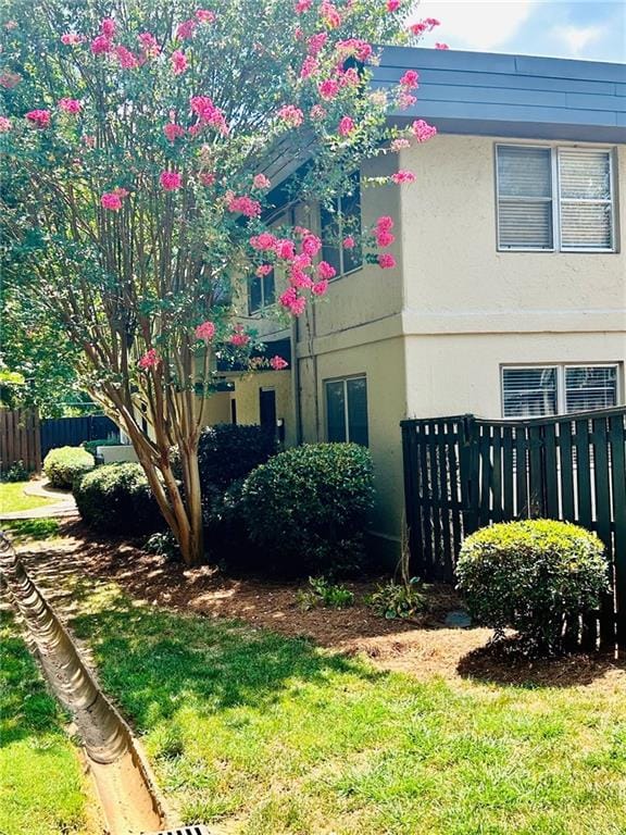 view of home's exterior featuring a yard, fence, and stucco siding