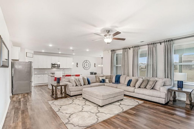 living room with a ceiling fan, recessed lighting, and wood finished floors