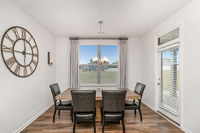 dining space featuring baseboards, visible vents, dark wood-style floors, and a chandelier