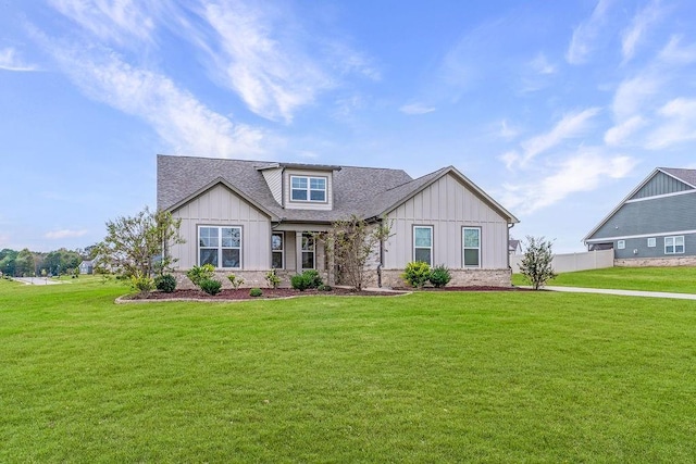craftsman house with a shingled roof, a front lawn, and board and batten siding