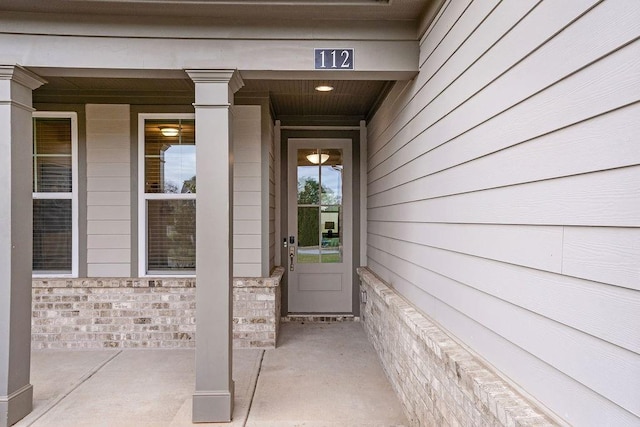 view of exterior entry featuring covered porch