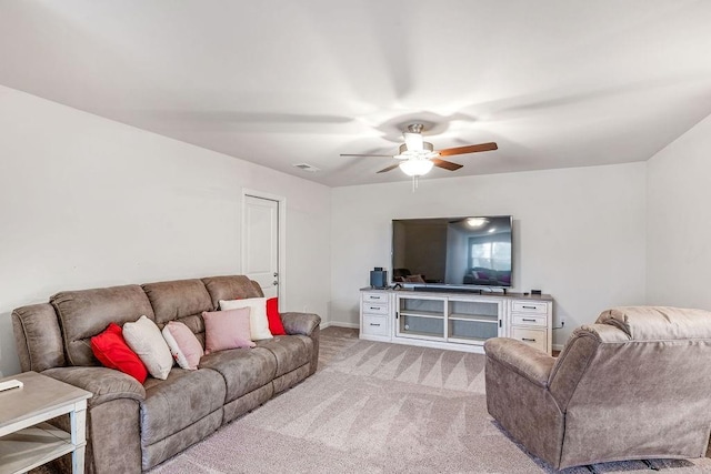 living area with a ceiling fan, baseboards, light colored carpet, and visible vents
