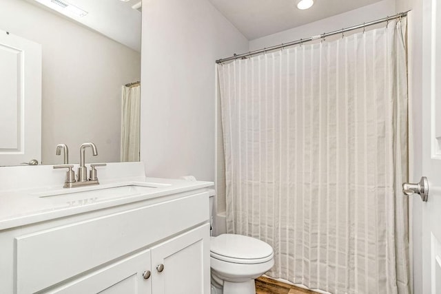full bathroom with visible vents, shower / bath combo, wood finished floors, vanity, and toilet