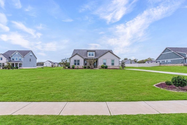 view of front of home featuring fence, board and batten siding, a front lawn, and stone siding