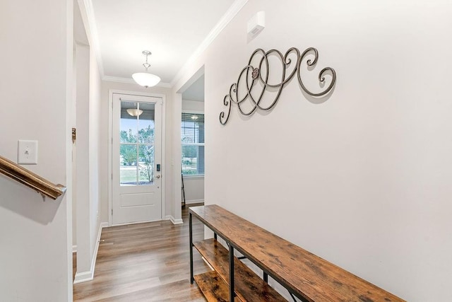 entryway with crown molding, baseboards, and light wood-style flooring