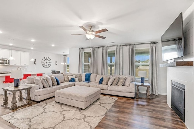 living room with a glass covered fireplace, recessed lighting, ceiling fan, and dark wood-style floors