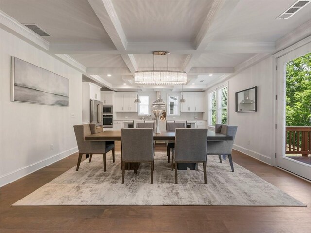 dining space with beam ceiling, coffered ceiling, a wealth of natural light, and hardwood / wood-style floors