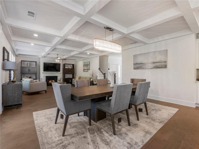 dining space featuring beamed ceiling, hardwood / wood-style floors, coffered ceiling, and ceiling fan