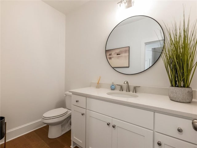 bathroom featuring toilet, vanity, and wood-type flooring