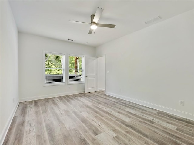 spare room with ceiling fan and light wood-type flooring